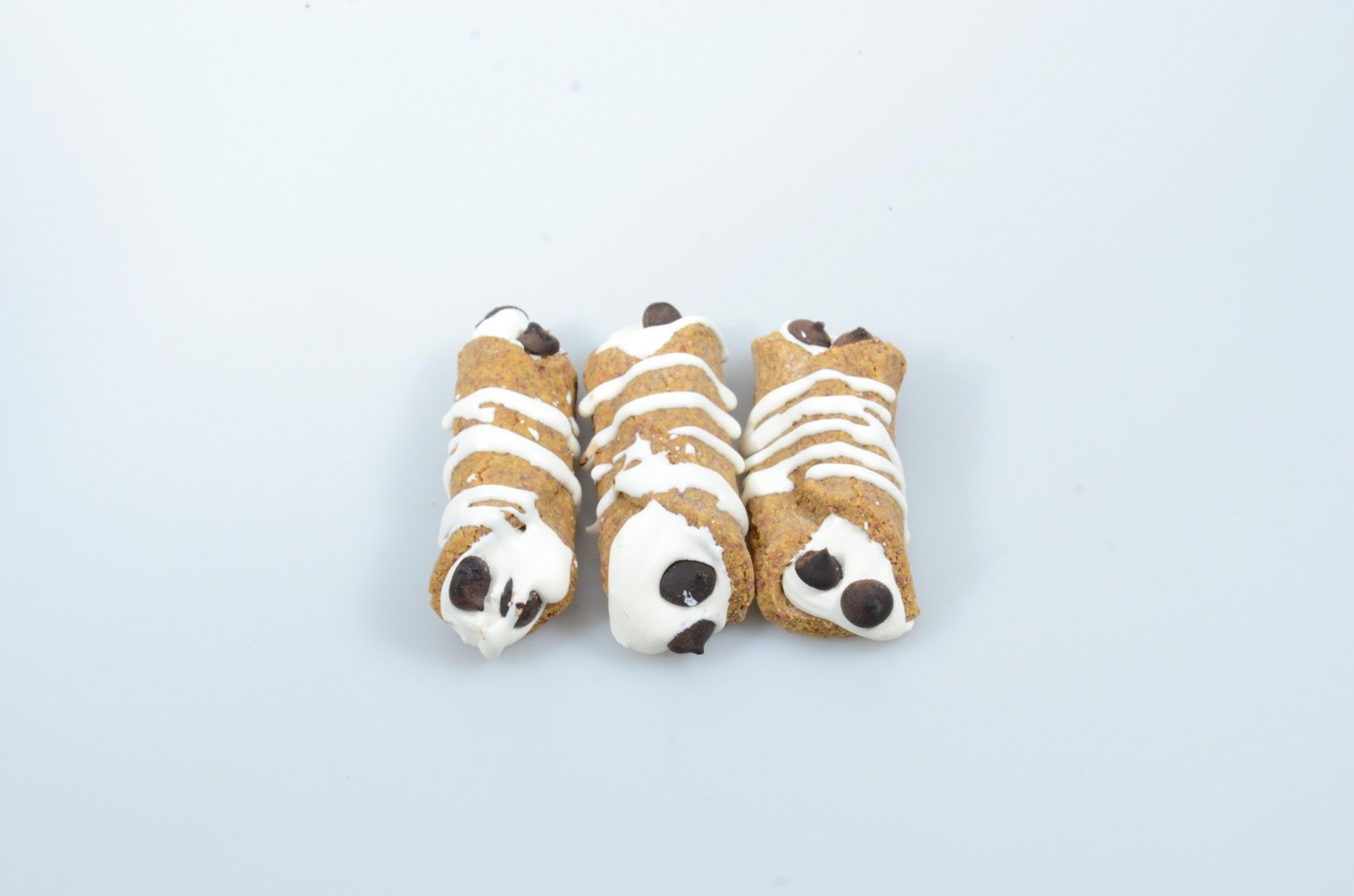 Three mummy-shaped decorated dog treats