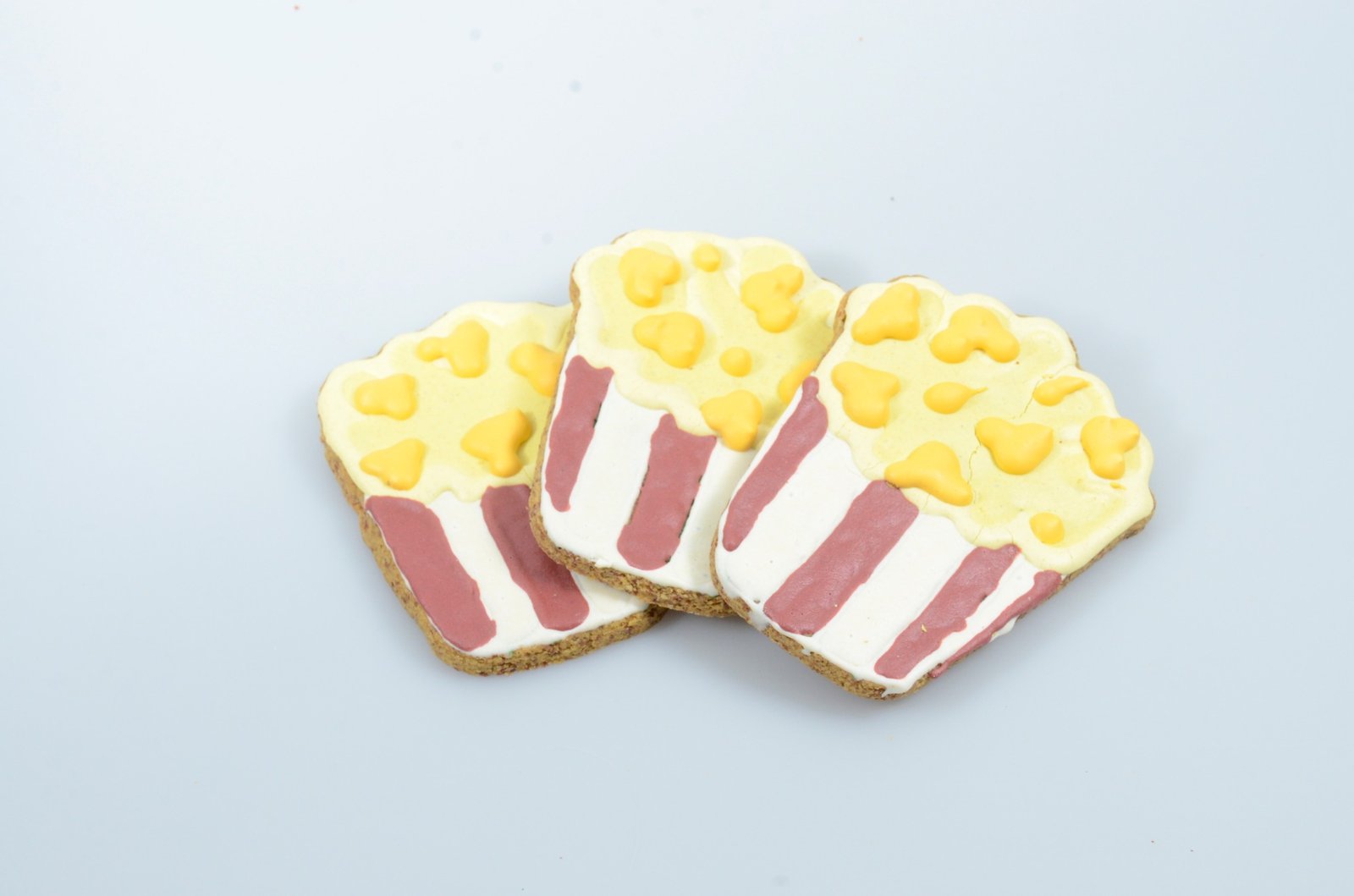 Three popcorn-box-shaped decorated dog treats